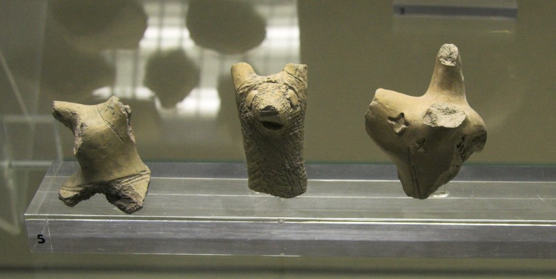 Fragments of terracotta figurines of the culture of Stentinello. In the center a clay dog head (Syracuse Regional Archaeological Museum)