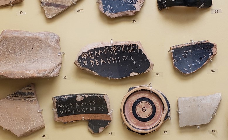 An ostrakon (Greek: ὄστρακον, plural ὄστρακα ostraka) is a piece of pottery, usually broken off from a vase or other earthenware vessel. . The one at the top center bears the name of the famous statesman Themistocles (ΘΕΜΙΣΤΟΚΛΗΣ). Ancient Agora Museum in Athens.